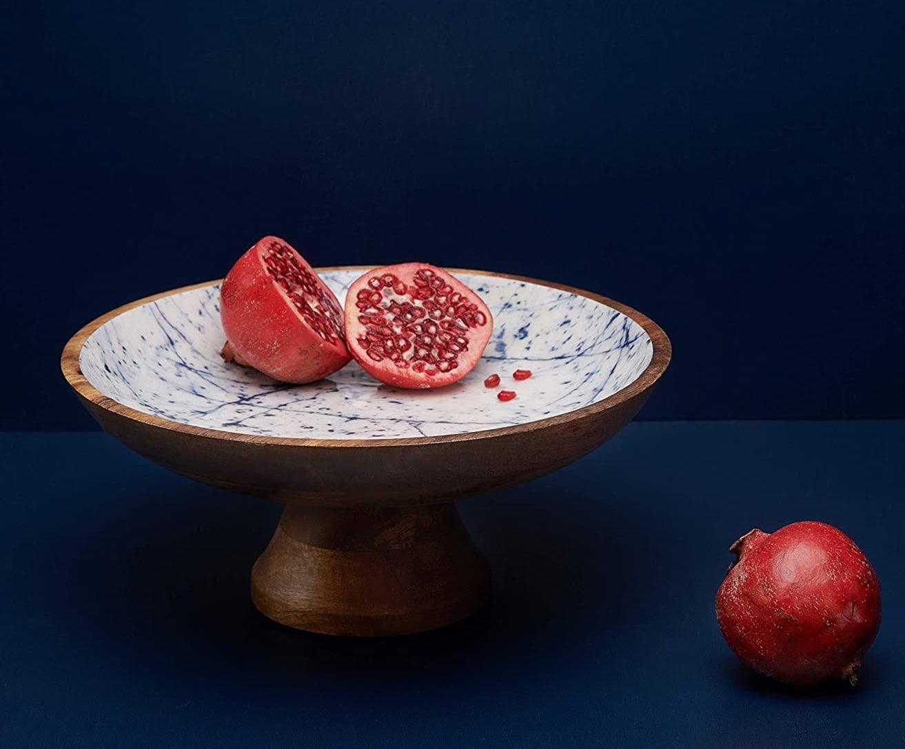 a mango wood fruit bowl on a pedestal leg with an abstract inside
