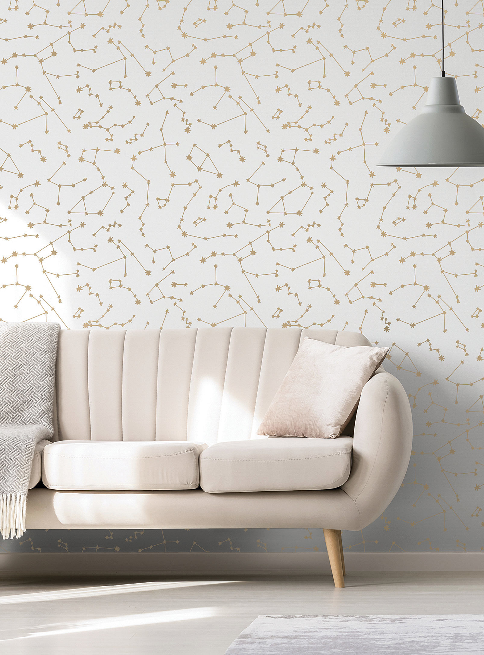 A wall covered in constellation wallpaper with a couch in front of it