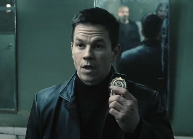 Mark Wahlberg as Max Payne holding his badge up