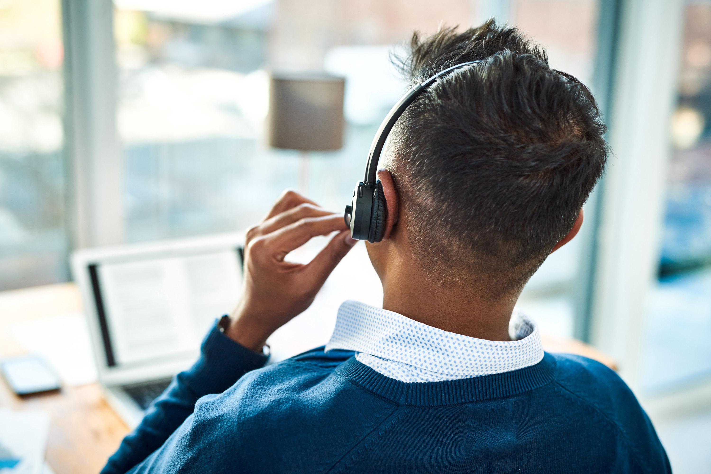 Man with a headset on looking out the window