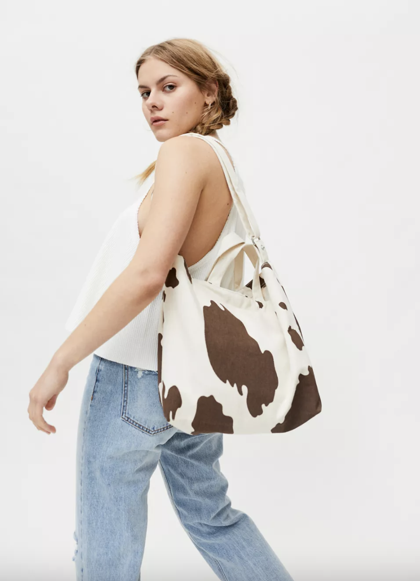 model carrying cow print tote bag with long shoulder straps