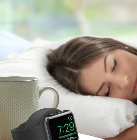An apple watch on the stand on a bedside table