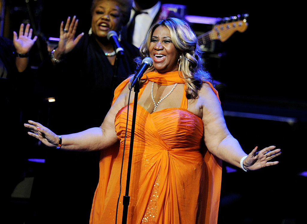 Aretha Franklin performs in an orange gown