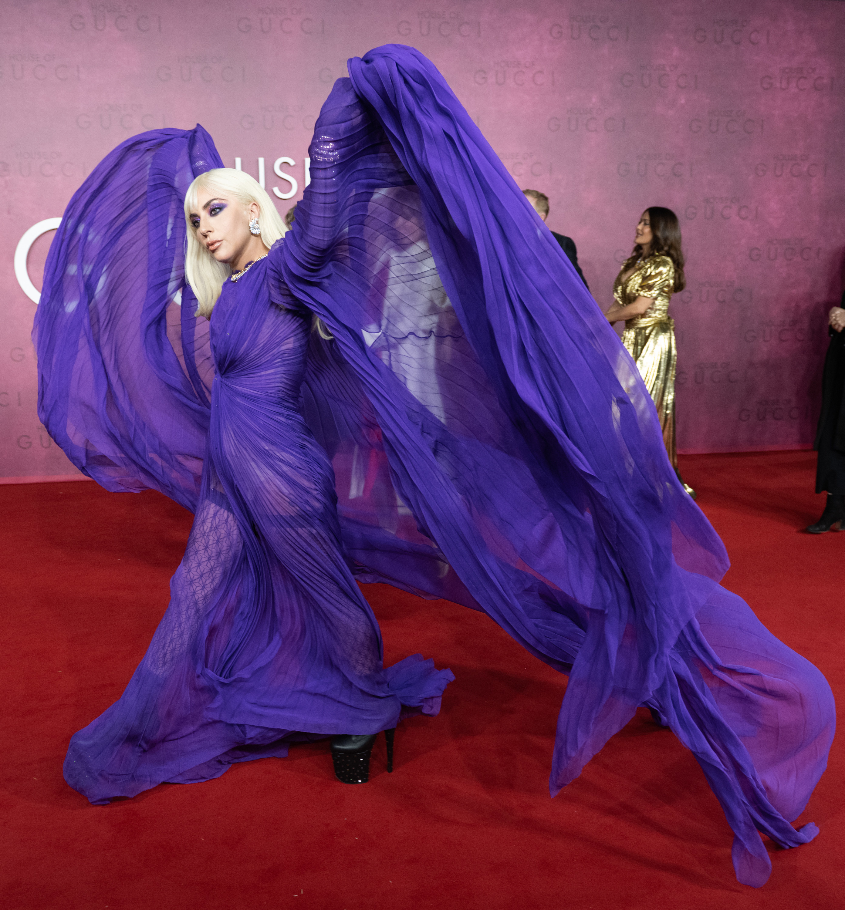 Gaga tossing up the cape of her dress at the premiere of House of Gucci