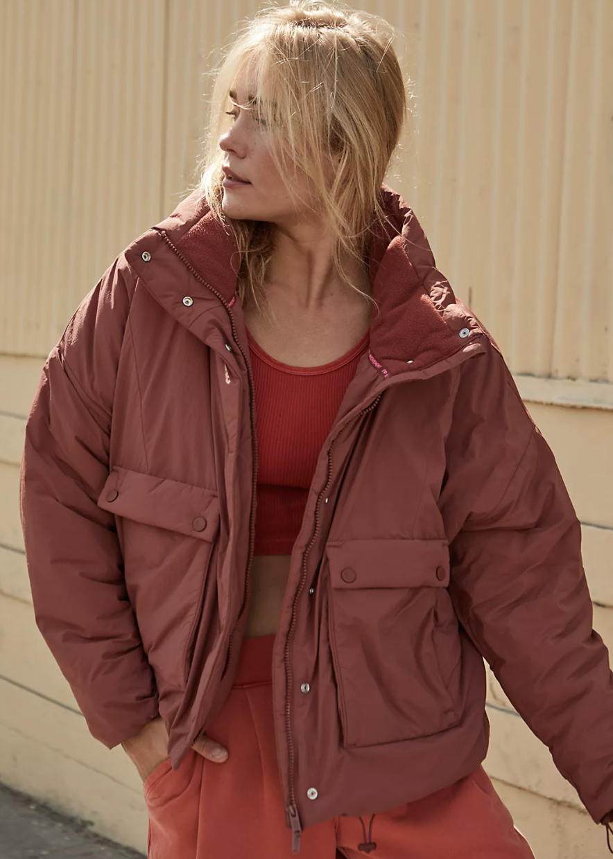 Model is wearing a red puffer jacker over a red top and red pants