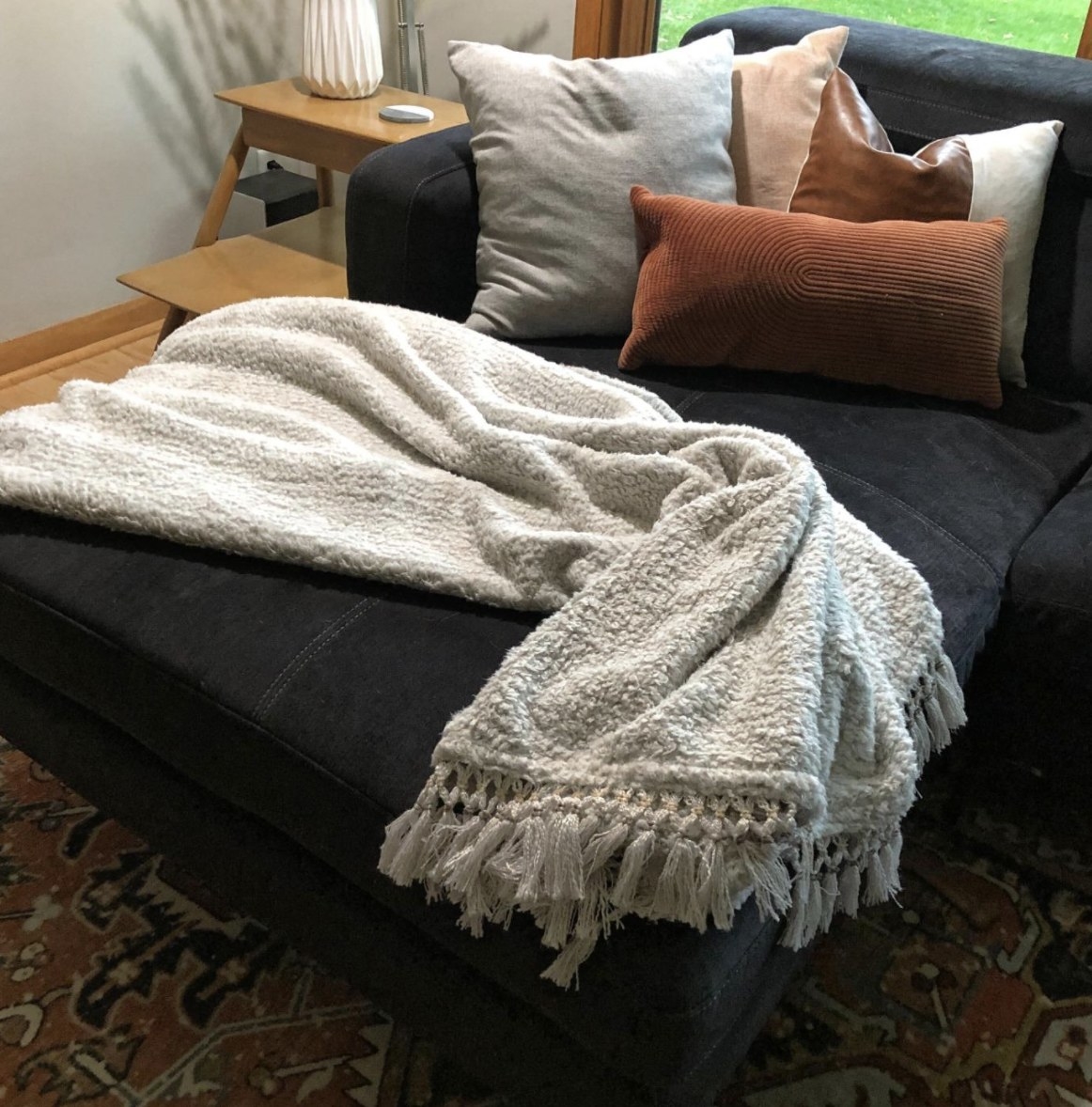 Reviewer&#x27;s photo of the white blanket on a sofa