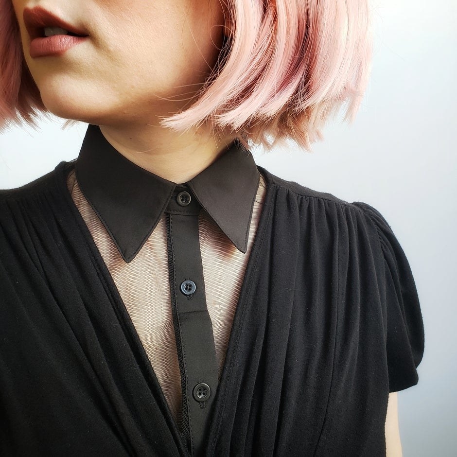 Model is wearing a black mesh collar under a black v-neck blouse