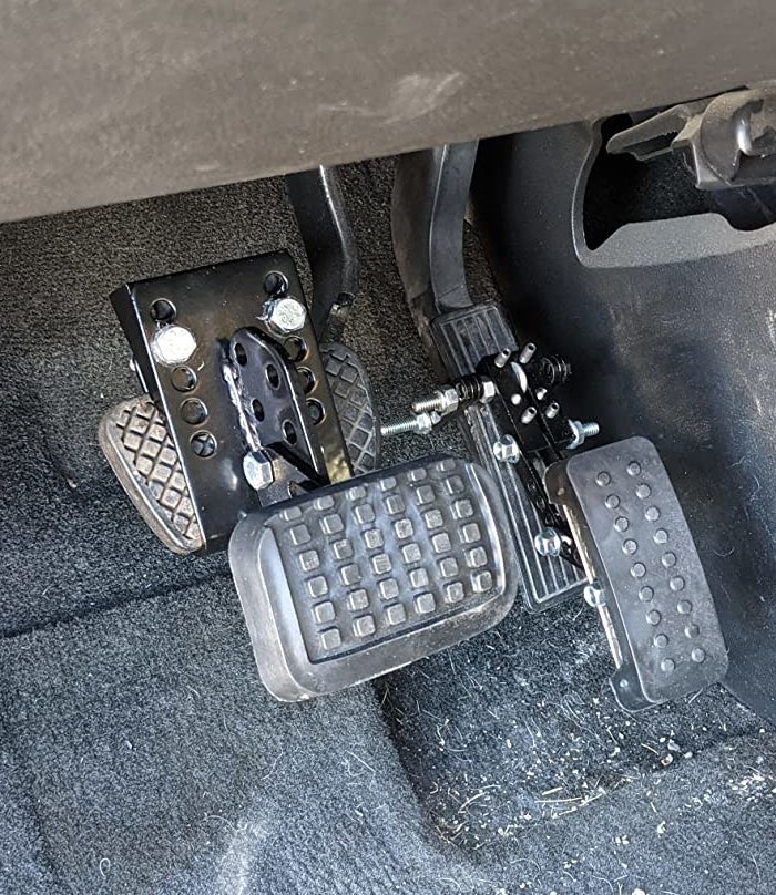 reviewer photo of the pedal extenders attached to their gas and brake pedals