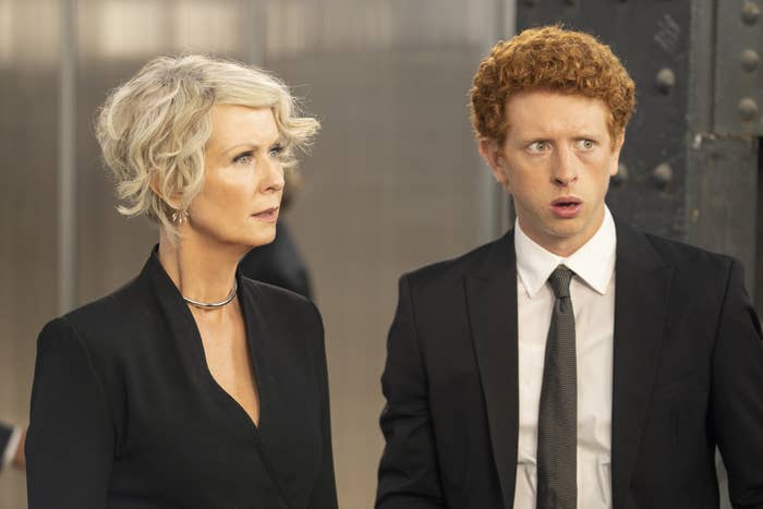 A white mother and son, bother wearing black suits, look shocked