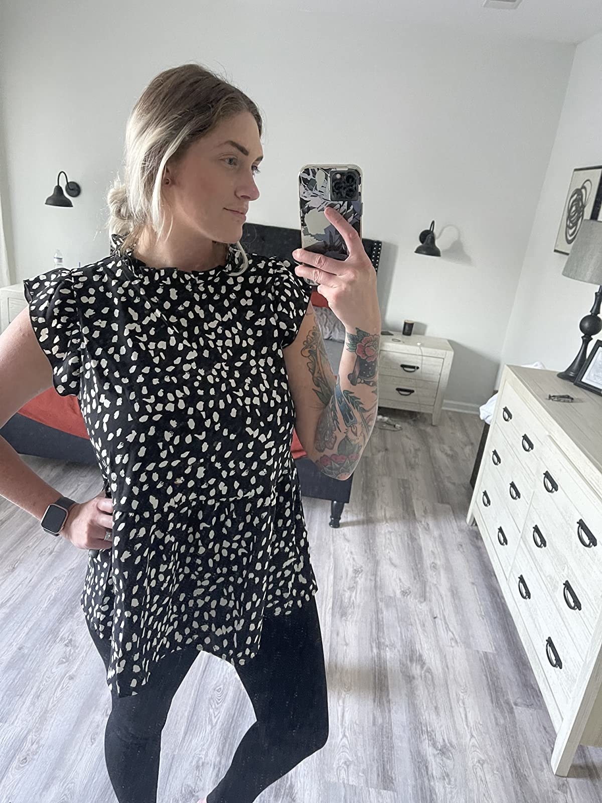 reviewer wearing black and white spotted top