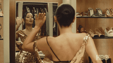 GIF girl looking in mirror with outfit changes