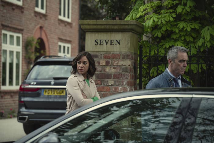 Two people walking by a car