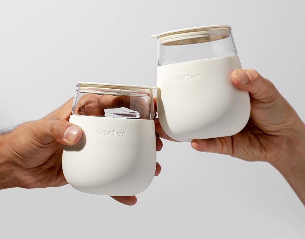 a pair of people clinking the portable cocktail mugs together