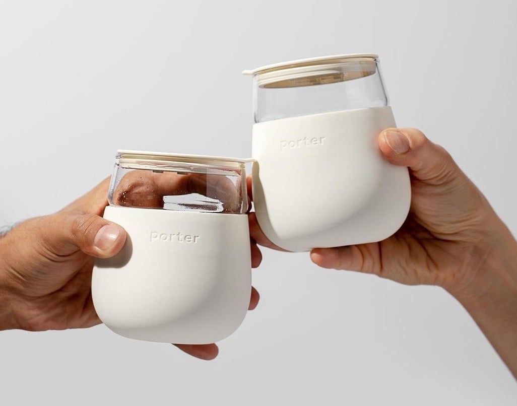 a pair of people clinking the portable cocktail mugs together