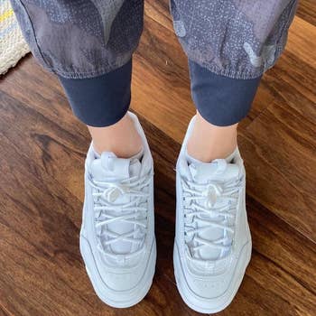 overhead view of reviewer's feet wearing the white platform sneakers