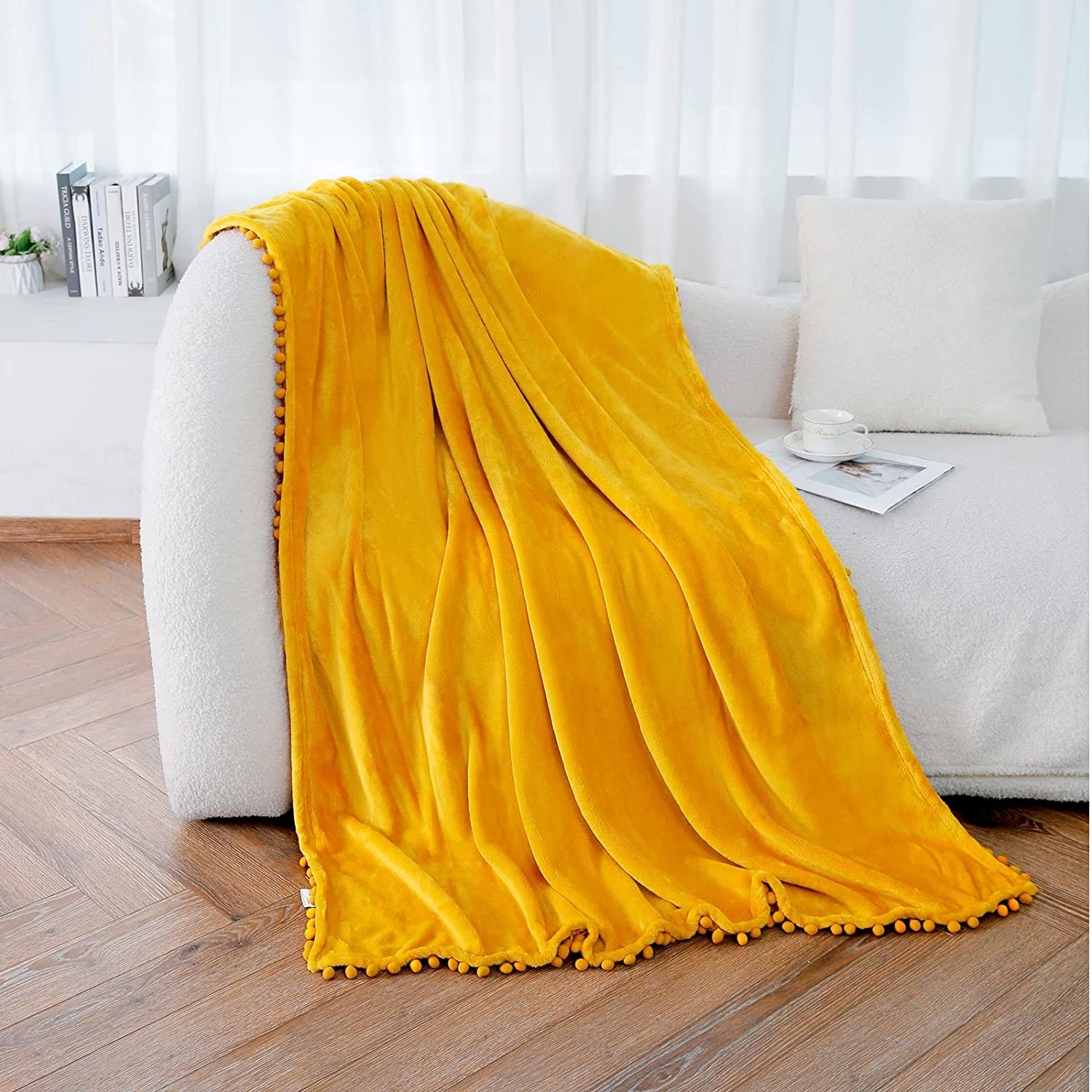 The throw blanket hanging over the side of a couch in a trendy living room