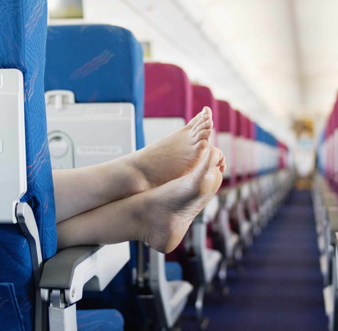 A passenger sticks their bare feet out into the aisle