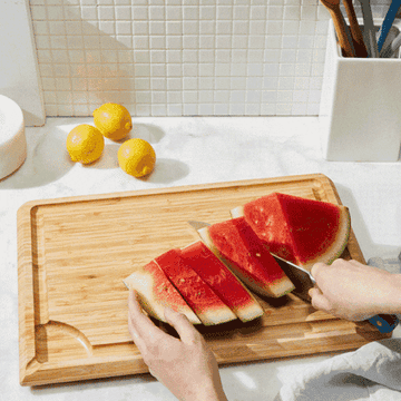 a gif of a model cutting up watermelon and draining the juice into a small bowl