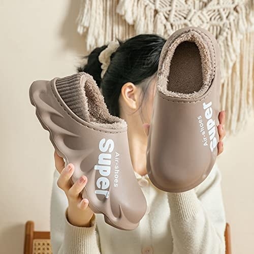 a person holding up a pair of the waterproof slippers