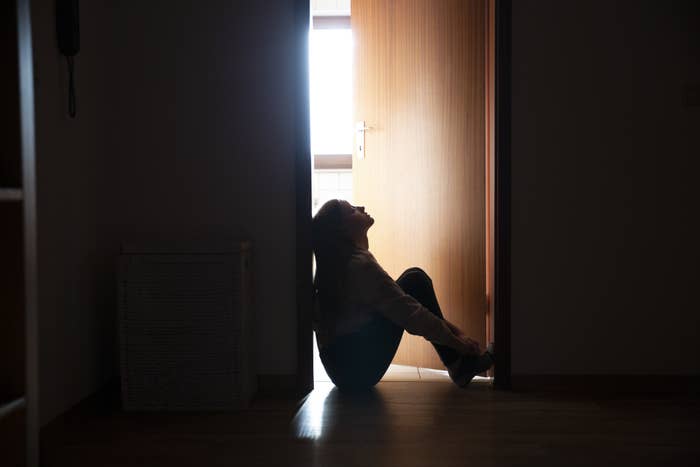 teen girl sitting solemnly in a doorway