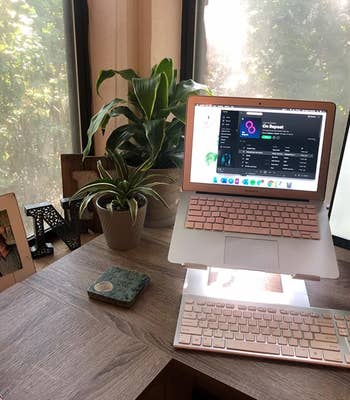 a reviewer's desk with their MacBook in the laptop stand