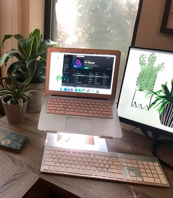 a reviewer's desk with their MacBook in the laptop stand