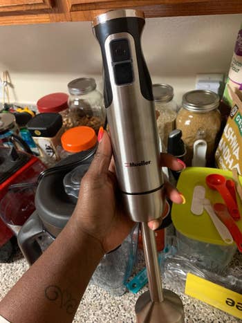 a reviewer holding up the stainless steel mixer