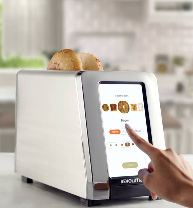 a model using the toaster to cook a bagel
