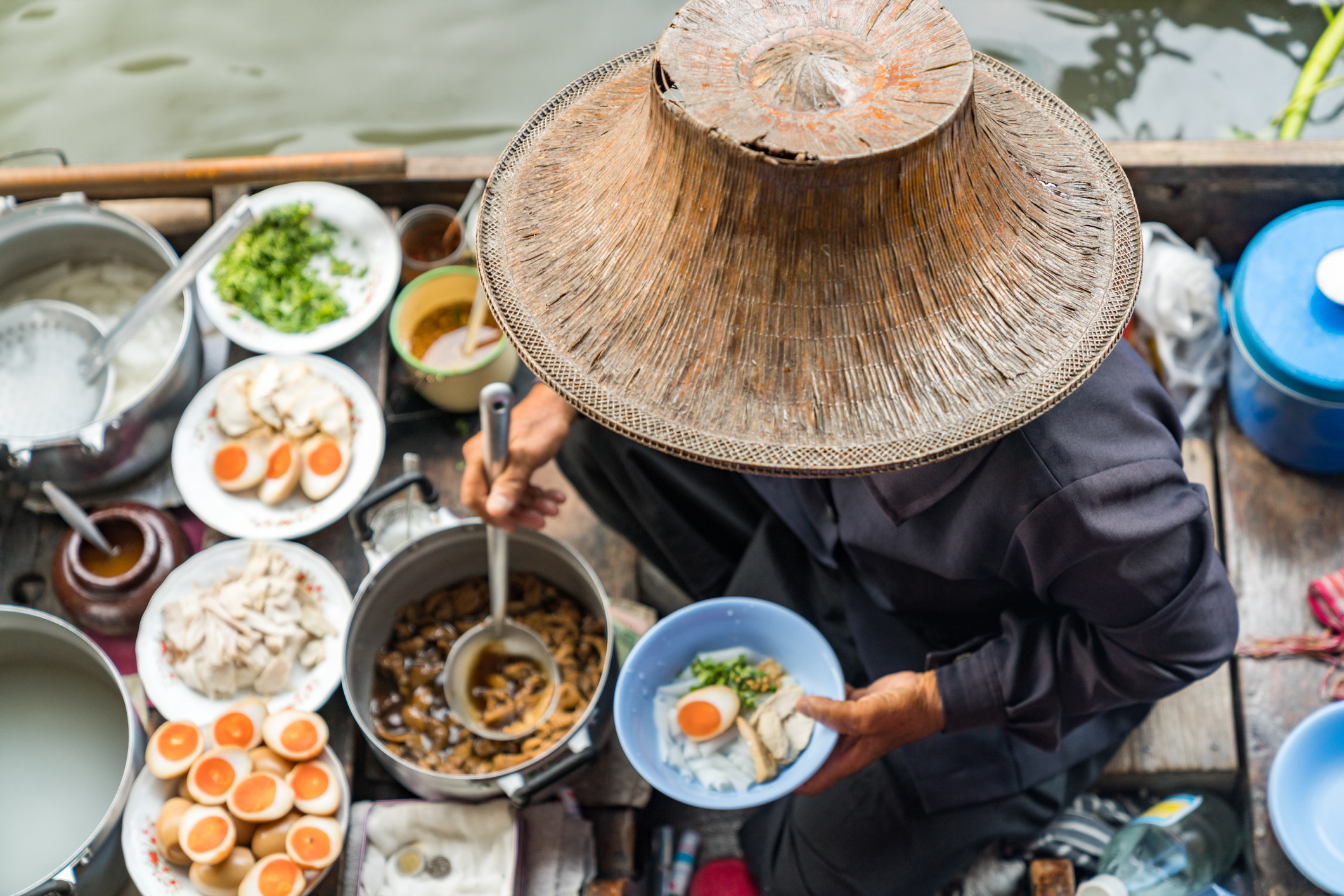 A woman serving food from a floating market.