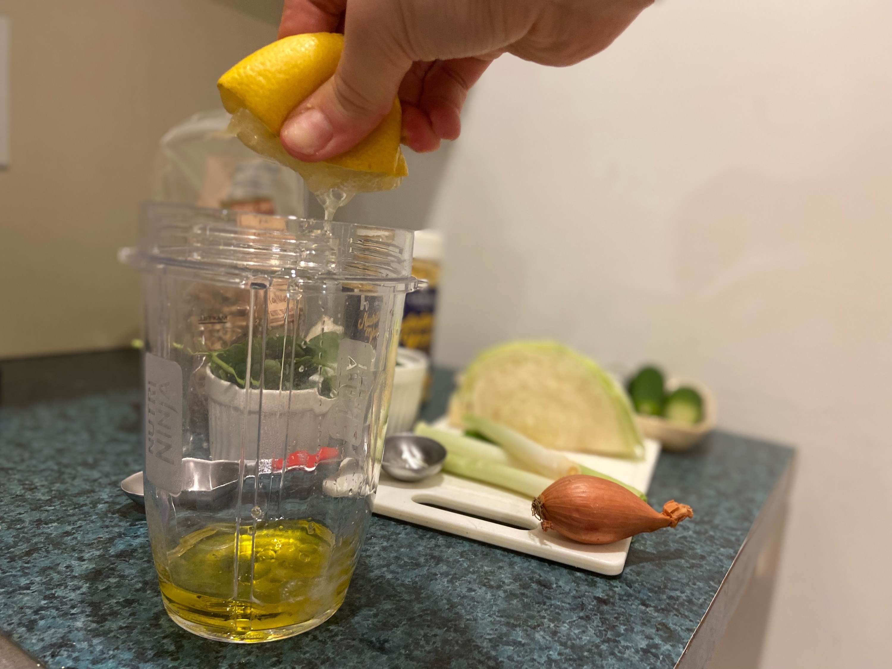 Jen squeezing lemon juice into measuring cup with the oil