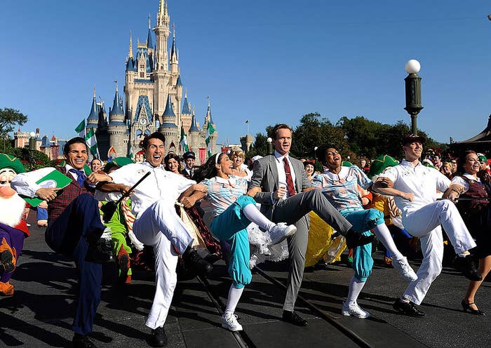 the actor dances in front of Cinderella Castle with a bunch of cast members