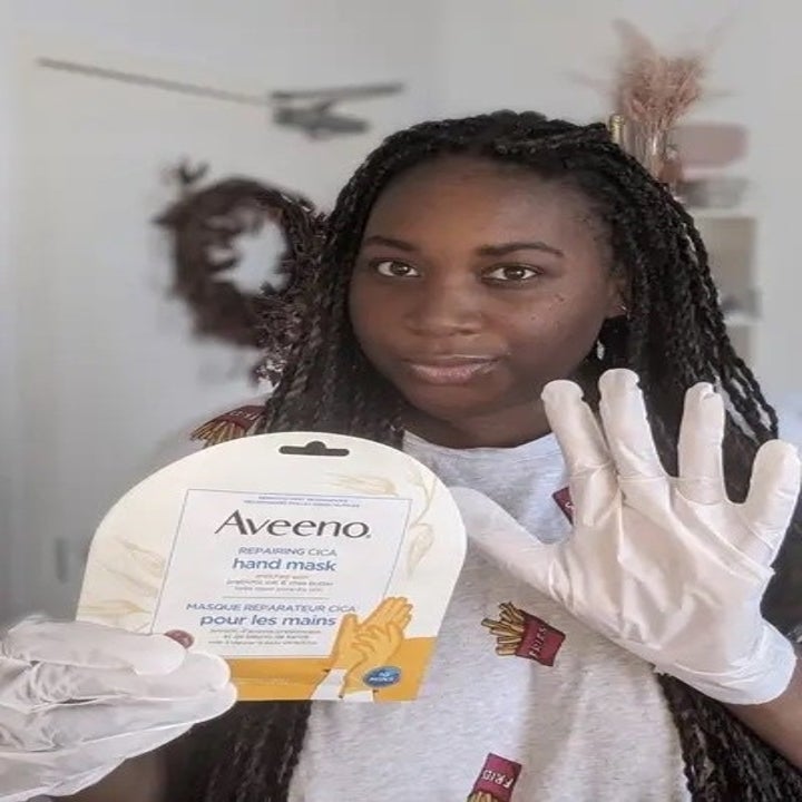 A person wearing the gloves and holding up the package