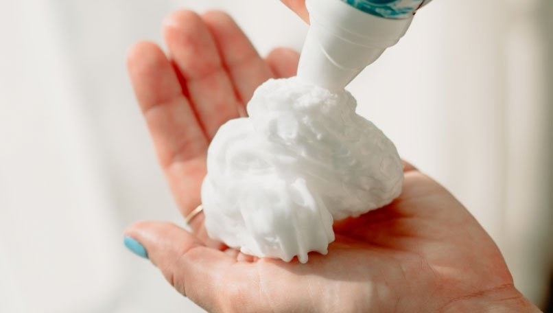 Someone dispensing a dollop of the cleansing foam into the palm of their hand
