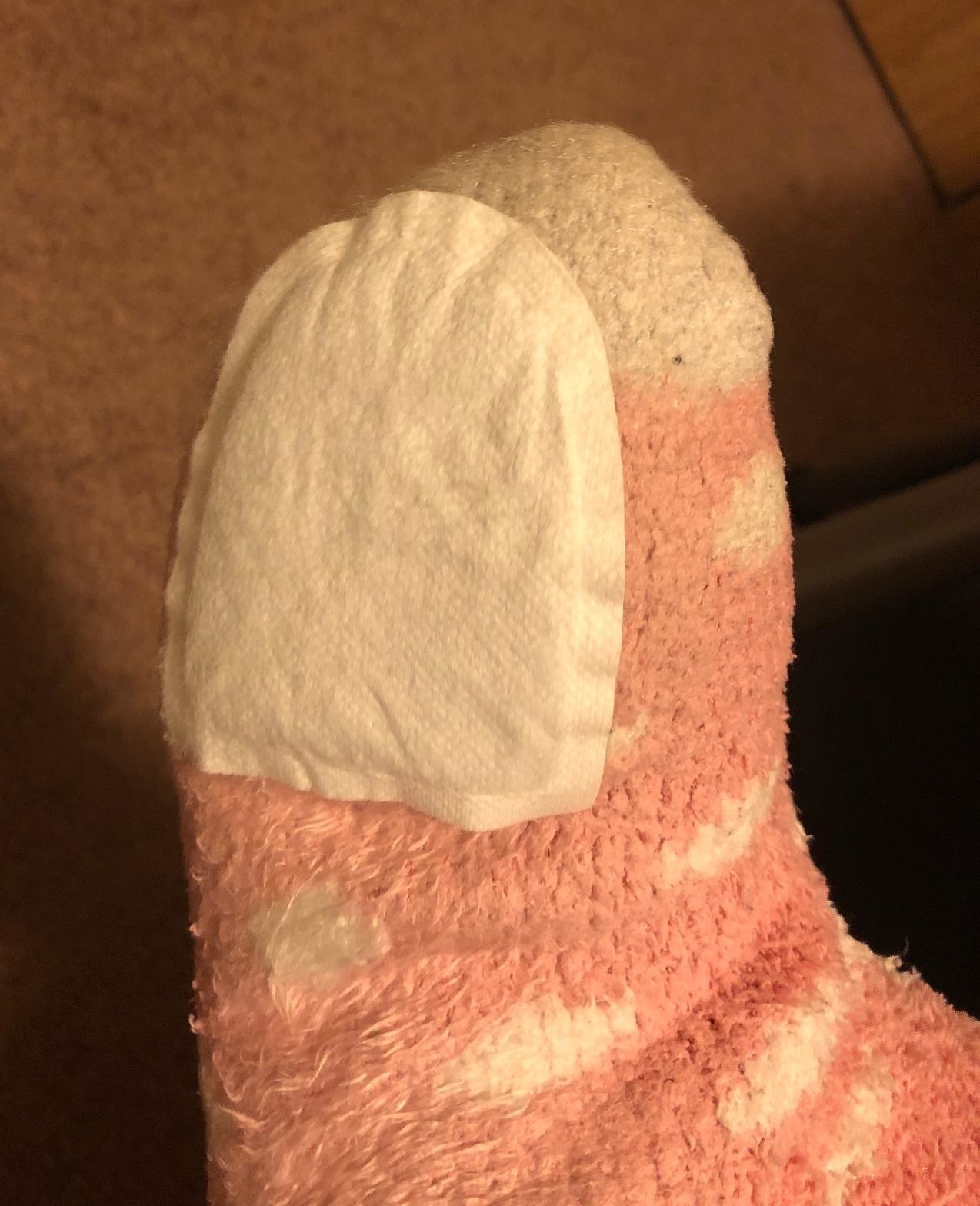 Reviewer is wearing the toe warmers on the bottom of their socks