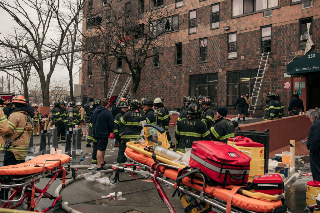 Firefighters and paramedics outside of the building with stretchers