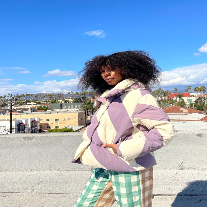 a model in the purple and white diagonally striped puffer