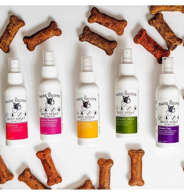 five spray bottles surrounded by bone-shaped dog toys