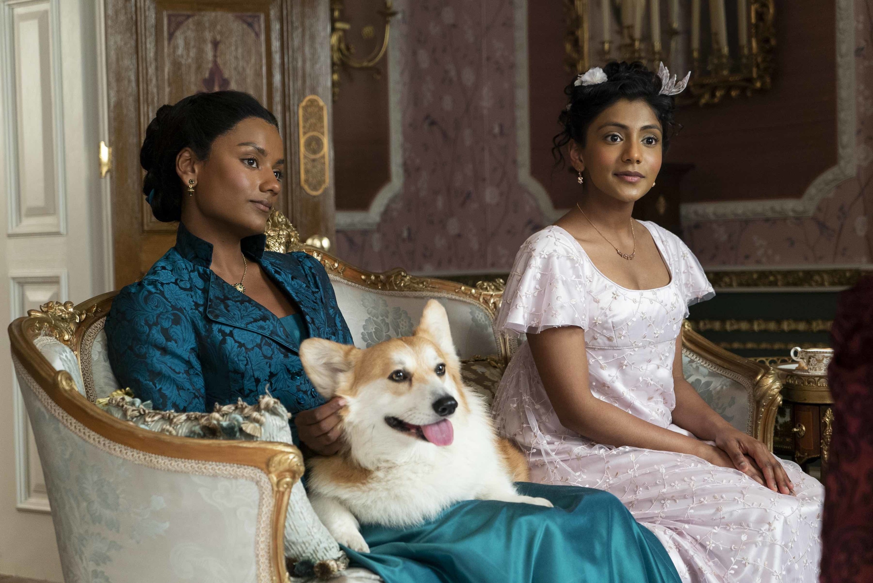 Kate, Edwina, and the Corgi sitting on an ornately decorated couch