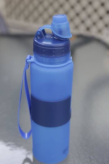 a reviewer photo of the blue water bottle completely erected
