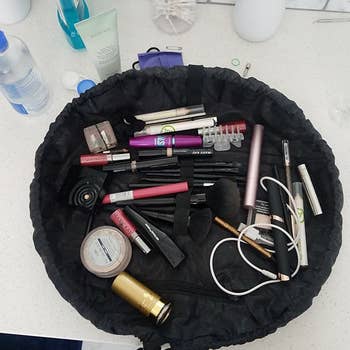 a reviewer photo of the makeup organizer spread out with various makeup products inside
