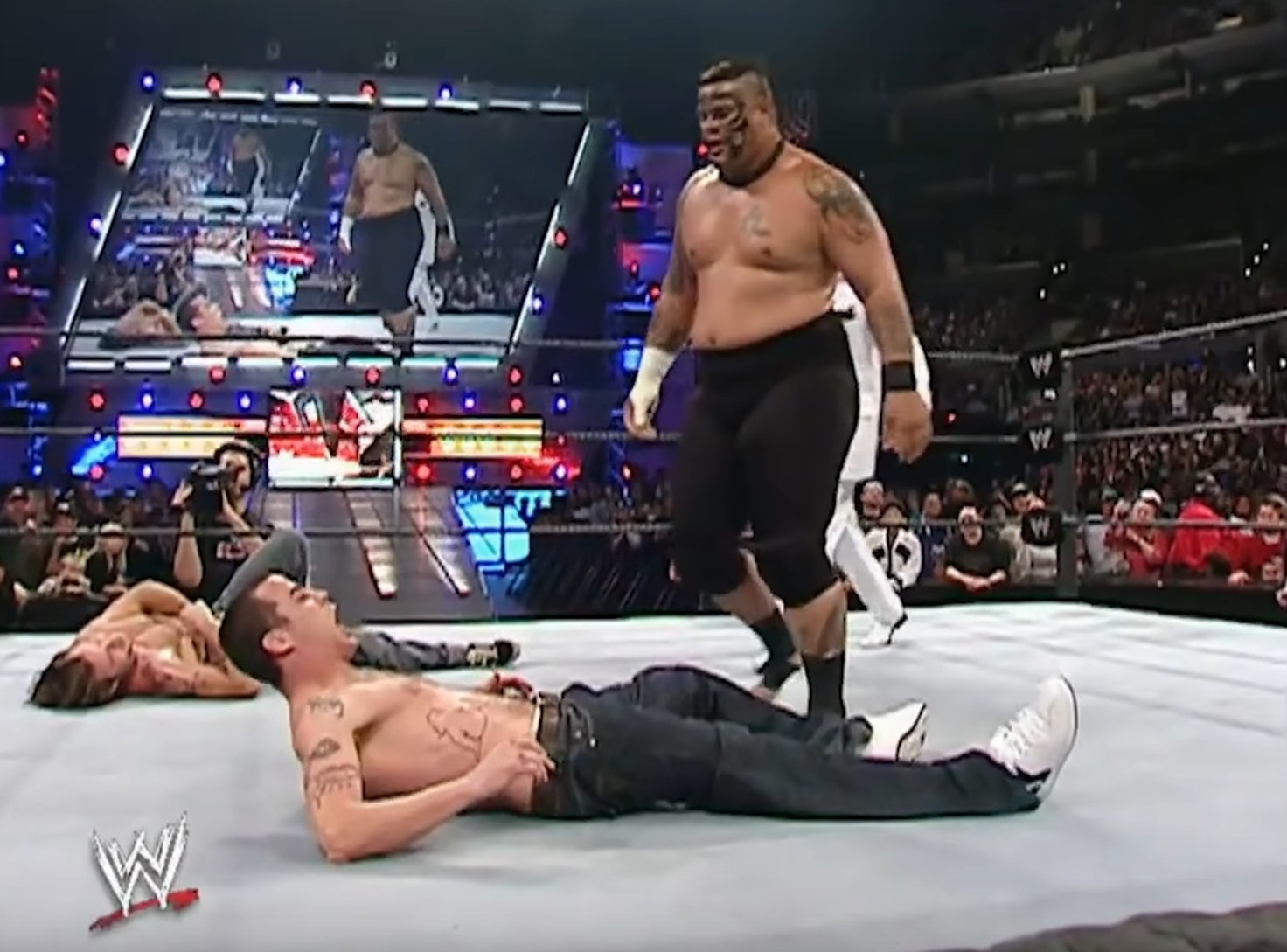 Steve-O screams in pain on his back in the ring while Umaga stands over him