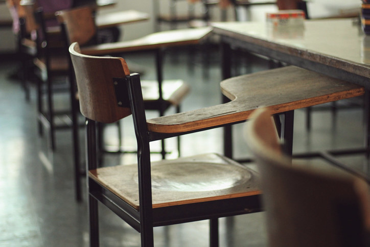 An empty chair and desk in a classroom