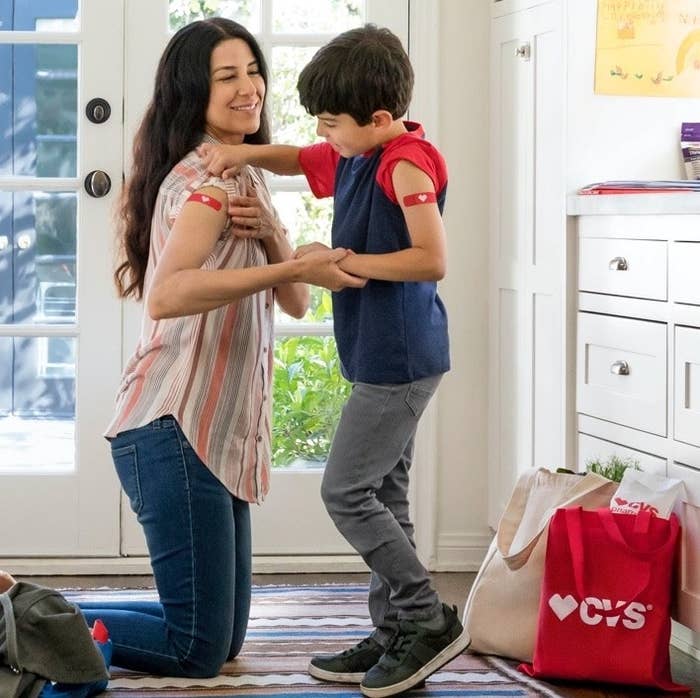 A person putting on bandaids with their kid