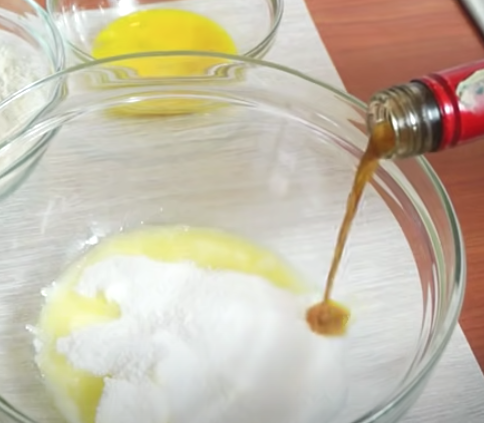 Pouring vanilla into a bowl of batter