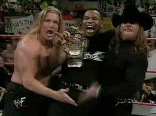 Mike Tyson celebrates with Triple H and Shawn Michaels