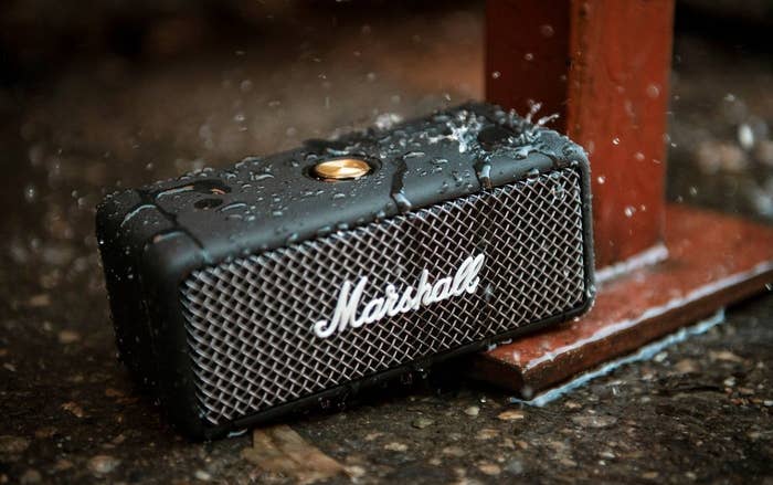 the rectangular black and silver speaker with the marshall logo on the front and water on it to show its water-resistant capabilities