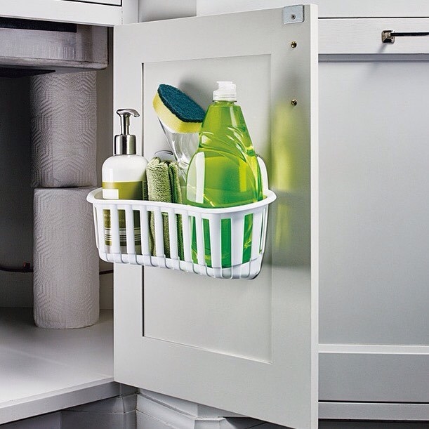 a storage caddy mounted on a kitchen sink cabinet