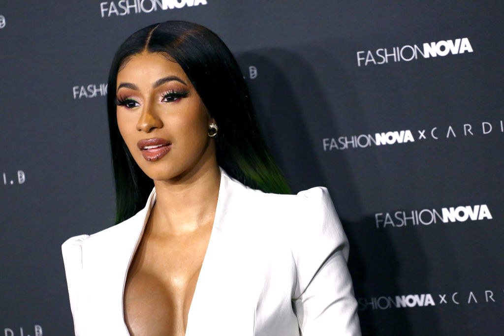 Cardi B at a Fashion Nova event; she&#x27;s wearing a blazer suit and looking away from the camera