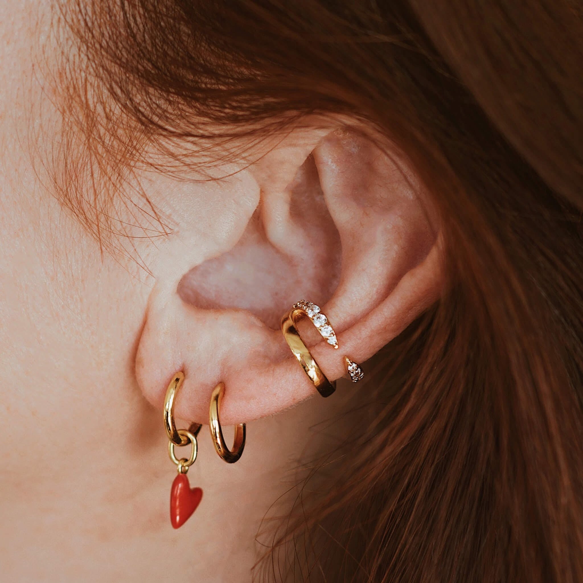 model wearing the gold heart charm earrings