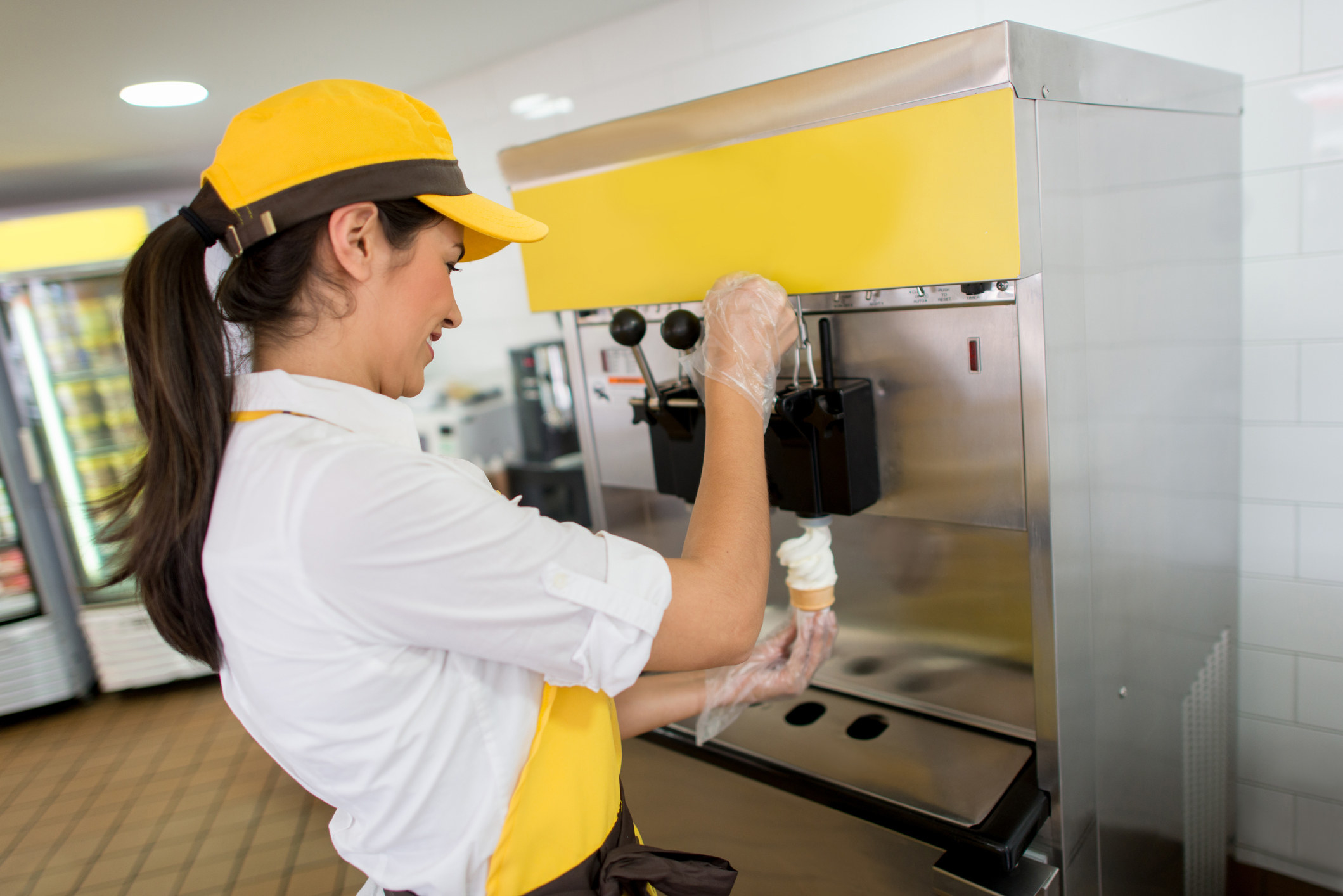 woman at a restaurant making an ice cream cone at the ice cream machine
